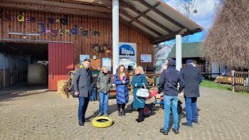 Sieben Personen stehen vor einer Scheune